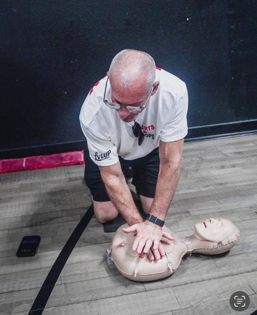 All Heart supporter practicing CPR at Hearts and Hoops event
