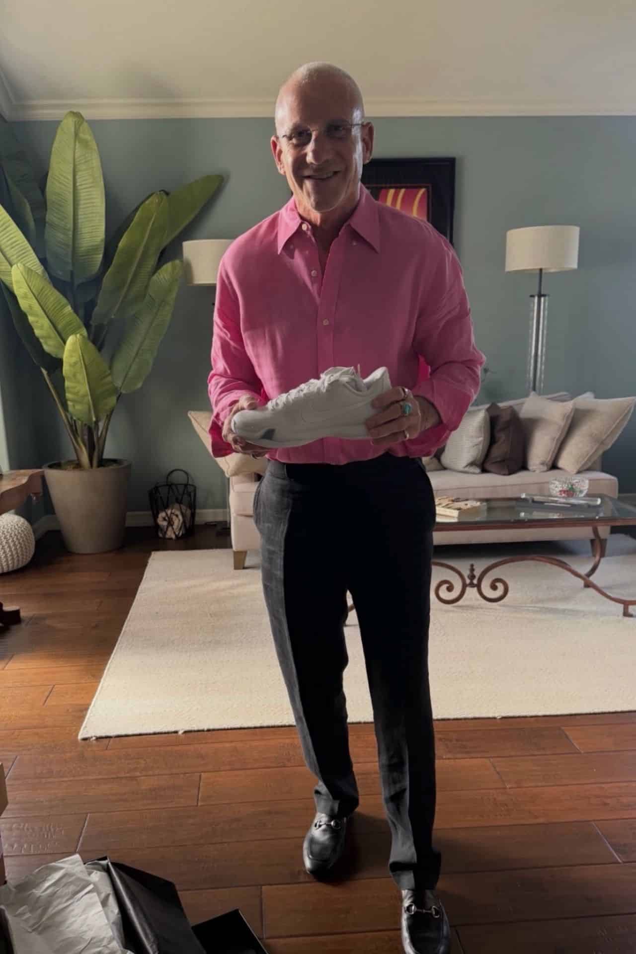 Jeff Pofsky holding white basketball shoes given to him by teammates Jason Levy and Jeremiah Guaman
