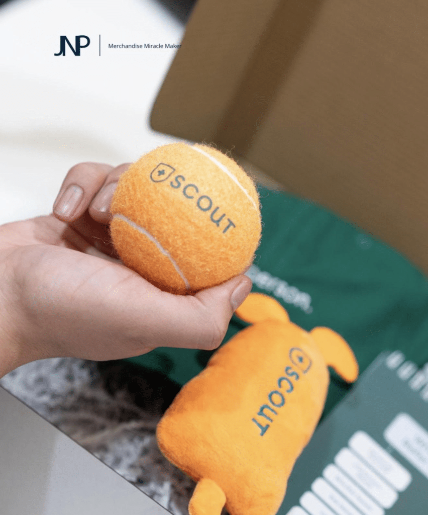 Yellow tennis ball featuring the Scout logo with coordinated merchandise in the background