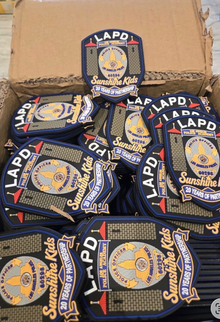 Box of custom LAPD and Sunshine Kids keepsakes with blue and gold 20 Years of Partnership designs